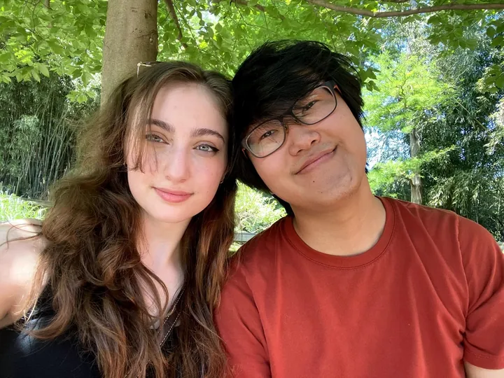 Hannah and Daniel cheek to cheek under the summer trees