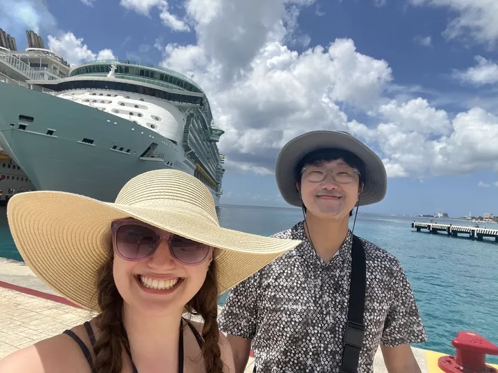 The two of us in sun hats on the dock, the ship behind us